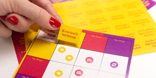 close up of he bingo sheet and prize stickers from a relationship card game intimacy bingo by joyful couple