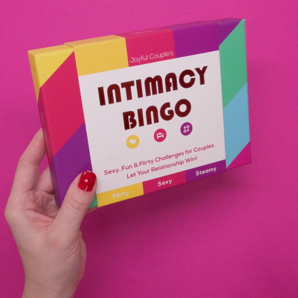 a woman holding the Intimacy Bingo in her hands and moving around the box, showcasing the game